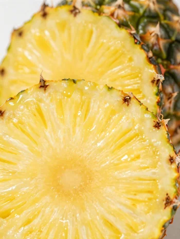 Świeży, pokrojony ananas na rustykalnym drewnianym stole