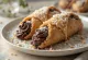 Cannoli z ciemną czekoladą i kokosem podane na talerzu