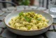 Kremowe risotto posypane pistacjami, podane w jasnej misce