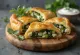 Spanakopita z ziołami, złocistobrązowe, chrupiące ciasto z bogatym nadzieniem szpinakowym