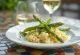 Kremowe risotto ze świeżymi zielonymi szparagami, posypane parmezanem, podane w stylu włoskim