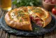 Calzone z salami, o złocistobrązowej skórce, nadziewane salami i serem