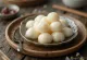 Chińskie knedle tang yuan podane w słodkim wywarze, z białymi kulkami