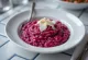 Risotto z burakami o kremowej konsystencji, podane ze świeżymi pietruszką i wegańskim parmezanem.