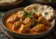 Kurczak tikka masala w kremowym sosie pomidorowym, udekorowany świeżą kolendrą