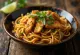 Mee Goreng z kurczakiem, podane ze świeżymi warzywami i jajkiem